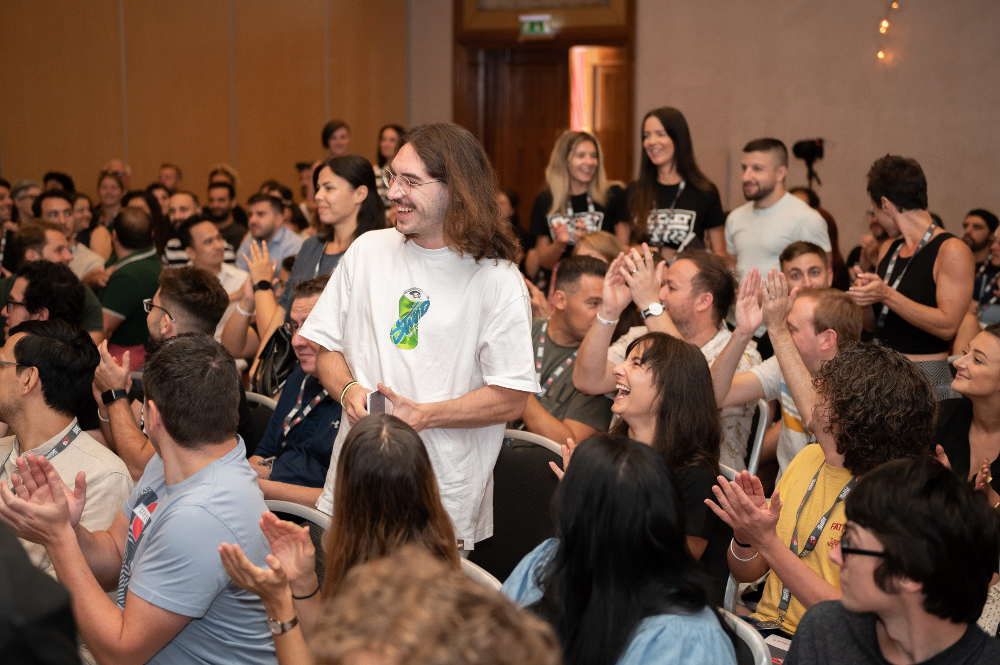 Irene Cecotti attending a work conference, engaging with a clapping audience in a conference room.